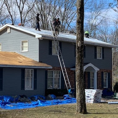 Roofing Contractors Prepping Roof for New Shingle Installation on Colonial House