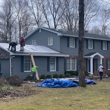 Roofers Installing Shingle Roof on Colonial House