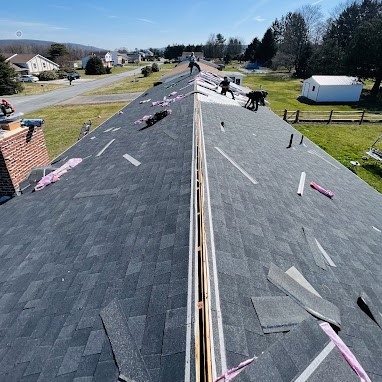 Roofers Working on an Almost Completed New Asphalt Shingle Roof Installation