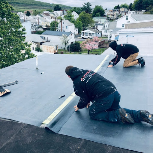 Two Roofing Contractors Installing Rubber Roof