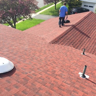 Roofing Contractor Finishes Up a Red Shingle Roof Installation